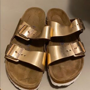 Gold Birkenstock’s with white bottoms
